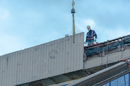 莫斯科 俄罗斯 05 10 2021 建筑物的修复 重建和维修 戴安全帽的建筑工人在结构的屋顶上安装混凝土板 房屋修复施工建设考图片