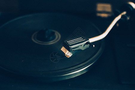 在城市灯光的日落背景上的黑胶唱机 DJ 混音和播放音乐的声音技术 黑胶唱片 1980 年老式乙烯基木电唱机 黑胶唱片针气氛玩家风图片