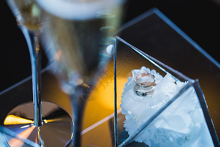 白花上一个玻璃盒子中的美丽优雅的结婚戒指图片