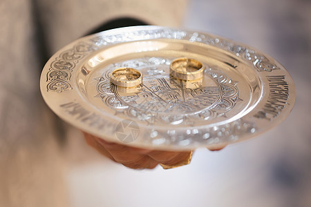 在牧师手里的金盘上戴着结婚戒指图片
