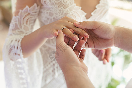 新郎把戒指贴在新娘的手指上 做特写妻子夫妻蜜月新人订婚家庭裙子婚姻女士庆典图片