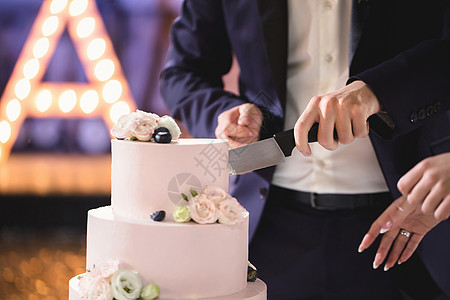 新娘和新郎在宴席上切了个漂亮的婚礼蛋糕盘子裙子传统接待结婚庆典仪式派对妻子男性图片
