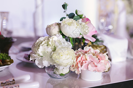 豪华婚礼宴会的餐桌布置 桌子上美丽的花朵服务花瓶接待用餐派对婚姻食物银器风格环境图片