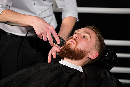 发型师用刀刮了男性胡子 帅哥被理发店的理发师剃了胡子 掌声造型师发型剃须刀理发修剪职业护理胡须工具刮胡子图片