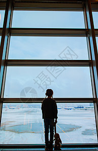 机场的小孩在等登机斗争童年木板窗户孩子闲暇旅游家庭玩具游客图片