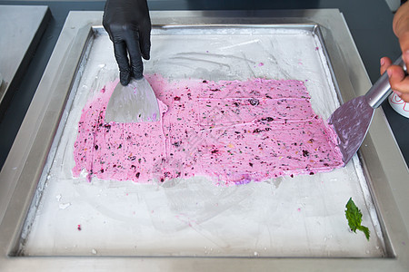在冷冻锅中炒冰淇淋卷 滚冰淇淋 手工制作的冰淇淋甜点 钢制冷冻锅炒冰淇淋机生产浆果平底锅烹饪美食餐厅巧克力技术食物机器图片
