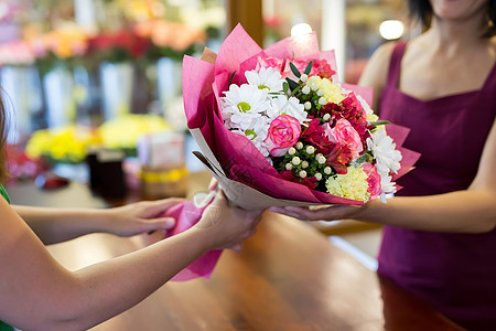 花店会给客户一束漂亮的花朵商业园艺礼物女性女士花园工人桌子成人植物图片