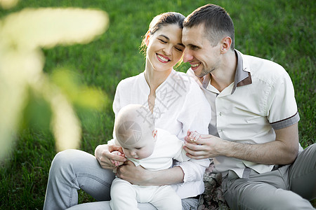 美丽的母亲 父亲和婴儿户外的肖像 夏日草原上幸福的家庭女士男性男生公园乐趣夫妻女性女儿儿子太阳图片