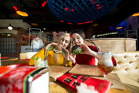 两个快乐的女孩吃汉堡 快餐的概念咖啡店食物自拍成人女士芝士面包午餐餐厅微笑图片