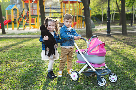 小男孩和小女孩 婴儿与婴儿车一起走路 买洋娃娃图片