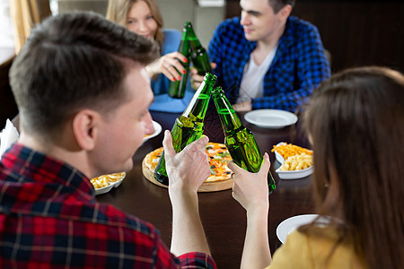 一群年轻朋友带着披萨和啤酒瓶在咖啡馆庆祝建筑长椅团体夫妻啤酒酒精快乐午餐餐厅乐趣图片