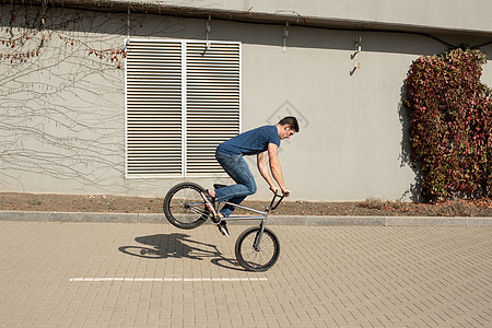 青少年BMX骑手在公园表演诡计小轮车乐趣娱乐空气男人风险自行车行动骑士速度图片