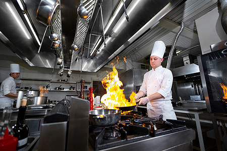 厨师在厨房炉子上用火烧锅煮饭酒店炊具燃烧油炸男性烤箱职业烹饪火焰餐厅图片
