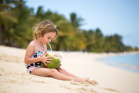 学龄前小女孩女孩在海边喝椰子汁图片