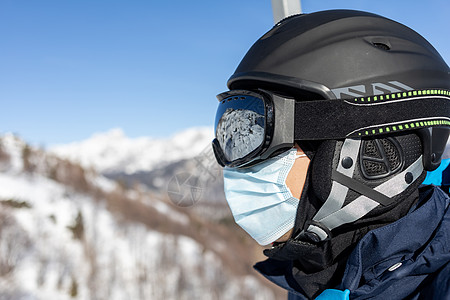 戴头盔和医疗面罩的脱衣男预防滑雪天气面具山脉空气蓝色玻璃假期男人图片