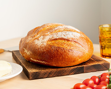 家里厨房桌上木板上的木头面包上一整包新鲜烤白小麦面包拓荒者小麦桌子面团食物美食包子脆皮健康乡村图片