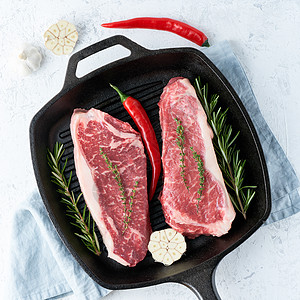 两块新鲜的鲜生大肉 牛肉片 大理石条形板 在铸铁大锅里图片