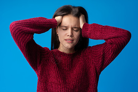 患有蓝背景头痛的年轻女青年白色成人疾病疼痛压力眼睛女士女性女孩图片