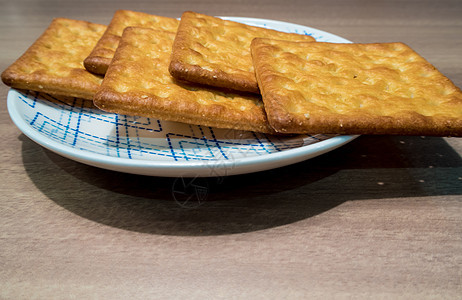 盘子里的饼干棕色蓝色小吃黄色团体食物圆形白色早餐小麦图片