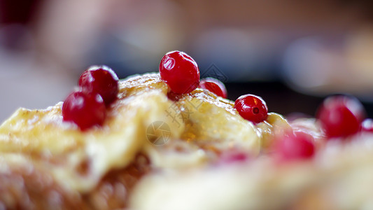 新鲜出炉的羊角面包 配上白色 柔软 甜美的奶油 盘子里放着红色浆果 在餐厅的深色木桌上享用欧陆式早餐 包括两个美味的羊角面包和奶图片