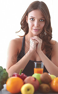 女孩坐在厨房的桌子上 果子和杯子加果汁女性成人水果女士衣服饮料橘味早餐房间玻璃图片