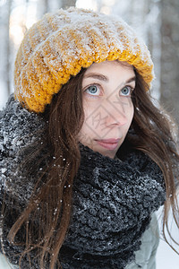 在雪林背景下 一位微笑着的年轻天主教女画像 戴着明亮的羊毛帽和围巾帽子羊毛针织帽衣服女性森林天气女孩女士图片