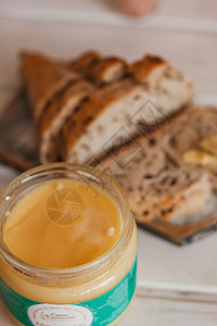 Ghee 黄油装在玻璃罐子和桌上的切片面包中 健康饮食 早餐奶牛液体美食营养奶制品茶几家具木头产品哺乳动物图片