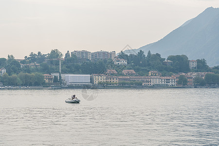 意大利Como湖山地山脉背景的机动船阳光巡航海岸活动速度发动机甲板天际汽艇奢华图片