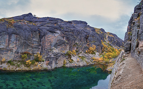 基比尼山脉的翡翠湖 带绿化水和岩石海岸的湖树木松树旅行石头全景远足天空森林爬坡反射图片