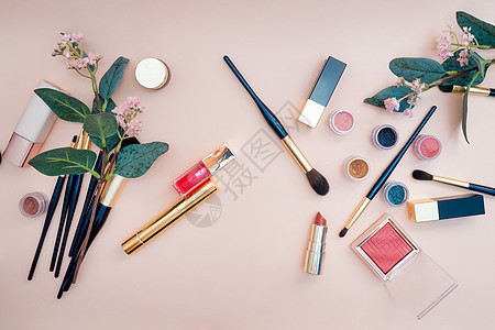 一套女性美容品和粉红色背景的眼罩化妆品睫毛膏工具花朵刷子配件美容调色板皮肤魅力女士图片