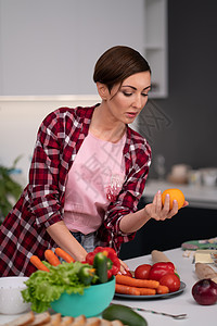 留着鲍勃发型的年轻漂亮家庭主妇在厨房里准备食物 选择番茄红或黄色 家里的健康食品 离开的健康食物-素食主义者概念图片