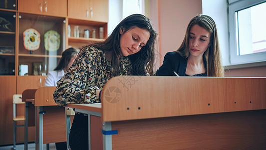 上课时课桌边的班级11年级学生 是俄罗斯学校的学生孩子们大学老师男生专注写作女孩们瞳孔童年女士图片