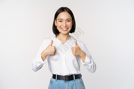美丽的亚洲成年女性竖起大拇指 穿着正式办公室 大学服装 推荐公司 站在白色背景上的形象员工快乐企业家管理人员女孩商业标识技术商务图片