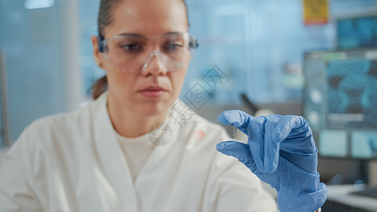 近距离的生物学家分析实验室玻璃器件上的血样图片