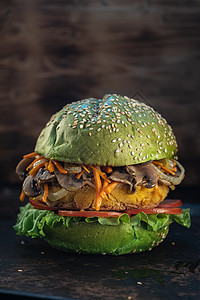 素汉堡 生菜 素食肉类替代品包括鹰嘴豆 玉米土豆 炸洋葱和胡萝卜 蘑菇生锈的烤棒 木制的背景 复制空间 垂直的图片
