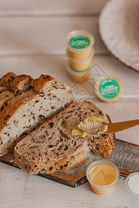 Ghee 黄油装在玻璃罐子和桌上的切片面包中 健康饮食 早餐桌子木头家具营养哺乳动物美食乡村产品咖啡菜肴图片
