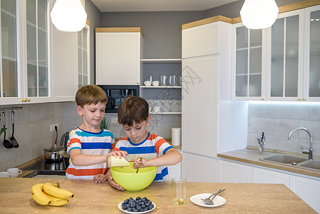 家庭快乐的有趣的孩子正在准备钱 在厨房烤饼干和烘饼烹饪食物童年面包师水果面包幸福帽子男生面团图片