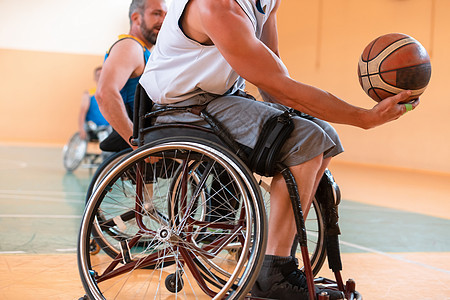 残疾人运动运动员在轮轮轮轮椅上打篮球的近身法庭篮子竞技成绩椅子成人男人退休团队游戏生活方式图片