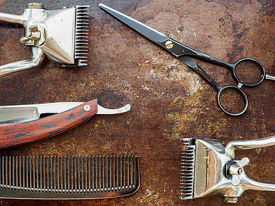 在生锈的表面是旧理发工具 传统手动剪头发梳子 剃须刀剃发剪剪刀图片