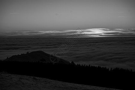 旅游和休闲的浪漫 以及健康生活方式的原则 是在德国黑森州最高的山上观看太阳光线从地平线落下的奇妙表演 呼吸新鲜洁净的山间空气黑白图片