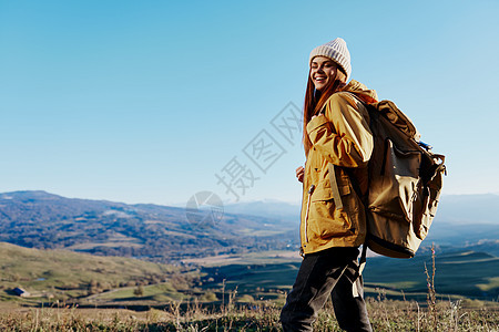 穿着黄色夹克的女人 在帽子背包 旅行山地放松图片