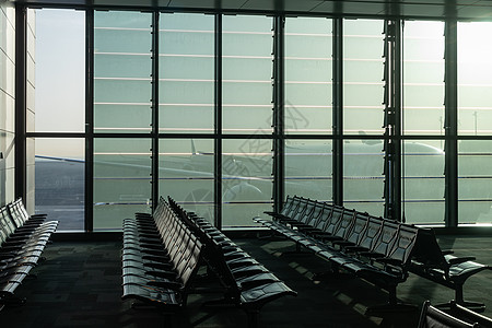 车站显示屏废弃的机场 全景窗边的空长椅 透过阿拉伯联合酋长国换乘枢纽的玻璃墙可以看到一架巨大的飞机建筑金属椅子休息室房间航班旅行建筑学飞机背景
