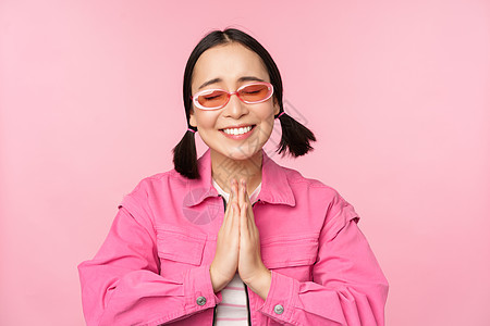 拜托 可爱的亚洲女孩求情 乞讨 站在工作室背景上大学微笑企业家工作情绪广告女士情感太阳镜商业图片