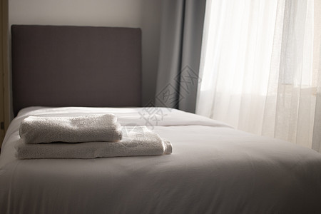 在旅馆床上堆叠的白色干净毛巾公寓风格服务寝具枕头奢华装饰床单家具折叠图片