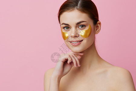 年轻女子脸上金色的金色面孔 特近式生活方式部位模特金子人体胶原面具皮肤保健美容睫毛膏图片