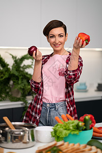 手持苹果的家庭主妇穿着格子衬衫 留着短发 站在厨房里做苹果派 家里的健康食品午餐乐趣食物童年蔬菜沙拉厨师义者女士食谱图片