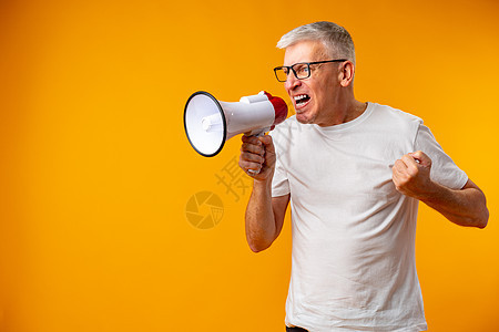 成年男子在黄色背景下用扩音器喊叫的肖像嗓音参考销售老年员工工作室退休商务注意力体积图片