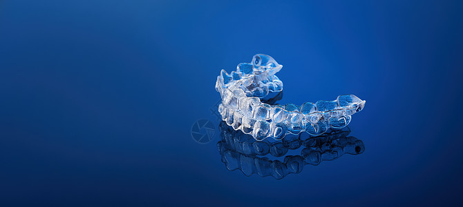 蓝色梯度背景 牙钉 塑料支架上隐形的矫正用化妆品括号 是拥有美丽的笑容和白牙的一种方式背景图片