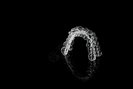 黑色背景上的隐形正畸美容支架 牙齿对准器 塑料支架 在 3d 打印机上创建的现代牙齿固定器 拥有美丽笑容和洁白牙齿的方法支撑保持图片