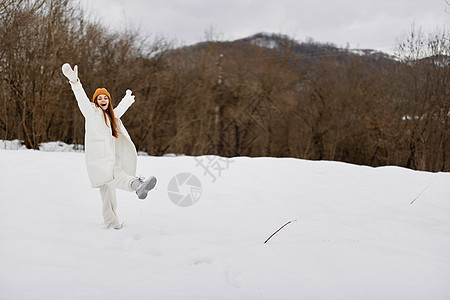 身着冬衣的年轻女子 在户外戴帽子 周围有很多雪图片